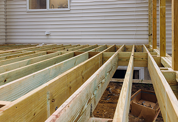 The image showcases a newly constructed wooden patio deck with elegant railings.